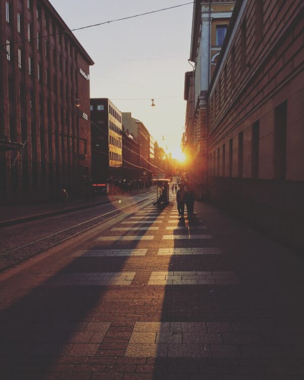 Solen står op på vejen mellem bygninger