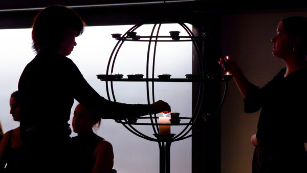 Kvinde tænder et lys i Enghave Kirkes lysglobe