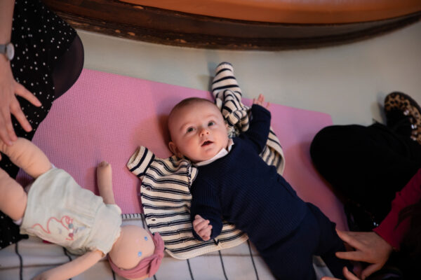 Baby ligger på gulvet og kigger op