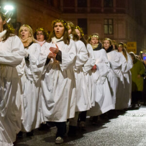 Luciaoptog, piger i hvidt med lys på gade på Vesterbro