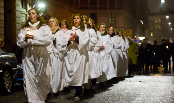 Luciaoptog, piger i hvidt med lys på gade på Vesterbro